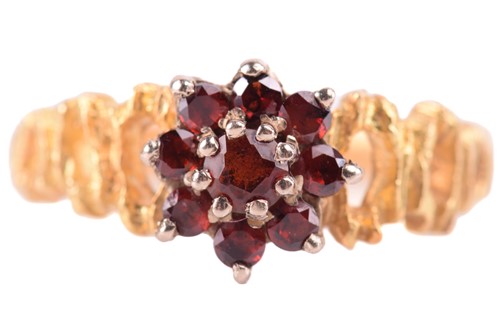 Lot 47 - A garnet cluster ring, with textured shoulders...