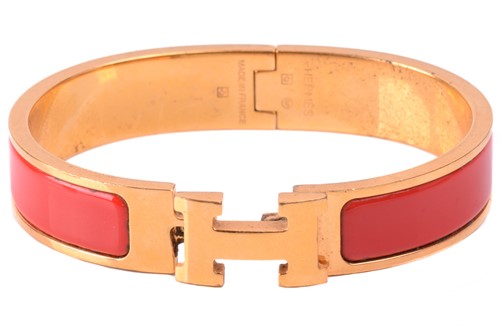 Lot 262 - Hermès - a narrow 'Clic H' bracelet with red...