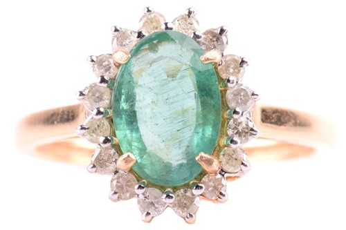 Lot 83 - An emerald and diamond halo ring, centred with...