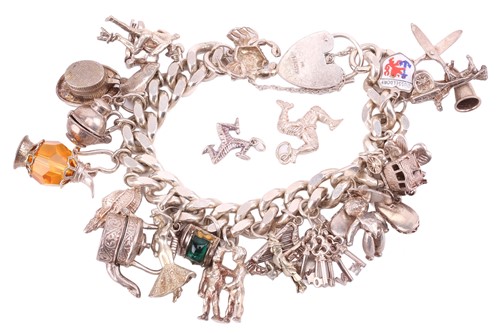 Lot 13 - A silver charm bracelet, the silver curb chain...