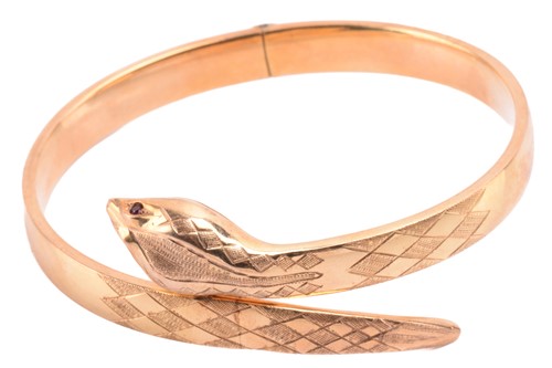 Lot 133 - A snake bangle in 9ct yellow gold, the...