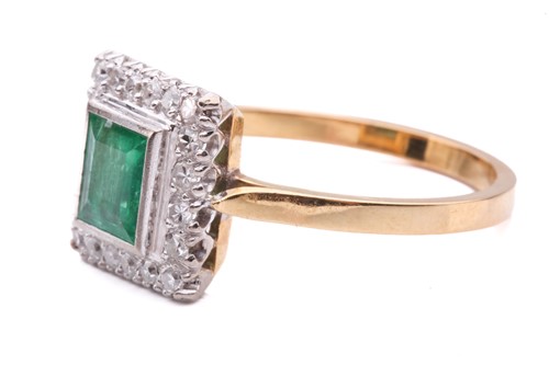 Lot 11 - An emerald and diamond halo ring, featuring a...