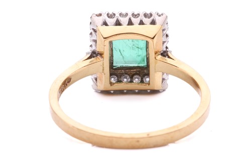 Lot 11 - An emerald and diamond halo ring, featuring a...