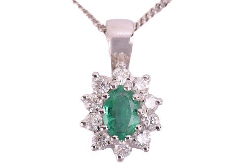 Lot 157 - An 18ct white gold emerald and diamond pendant;...