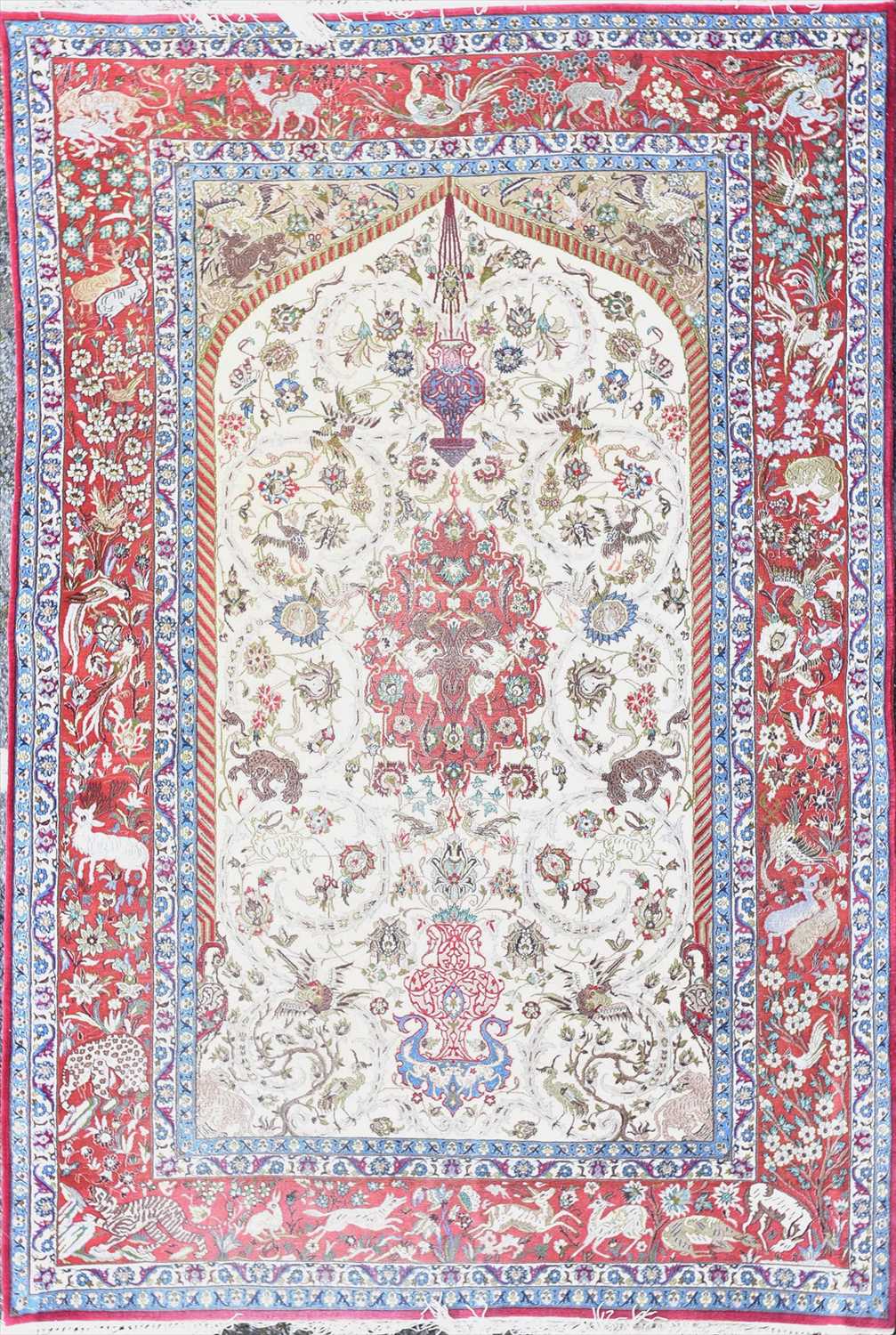 Lot 47 - A Persian red and cream ground rug polychrome...