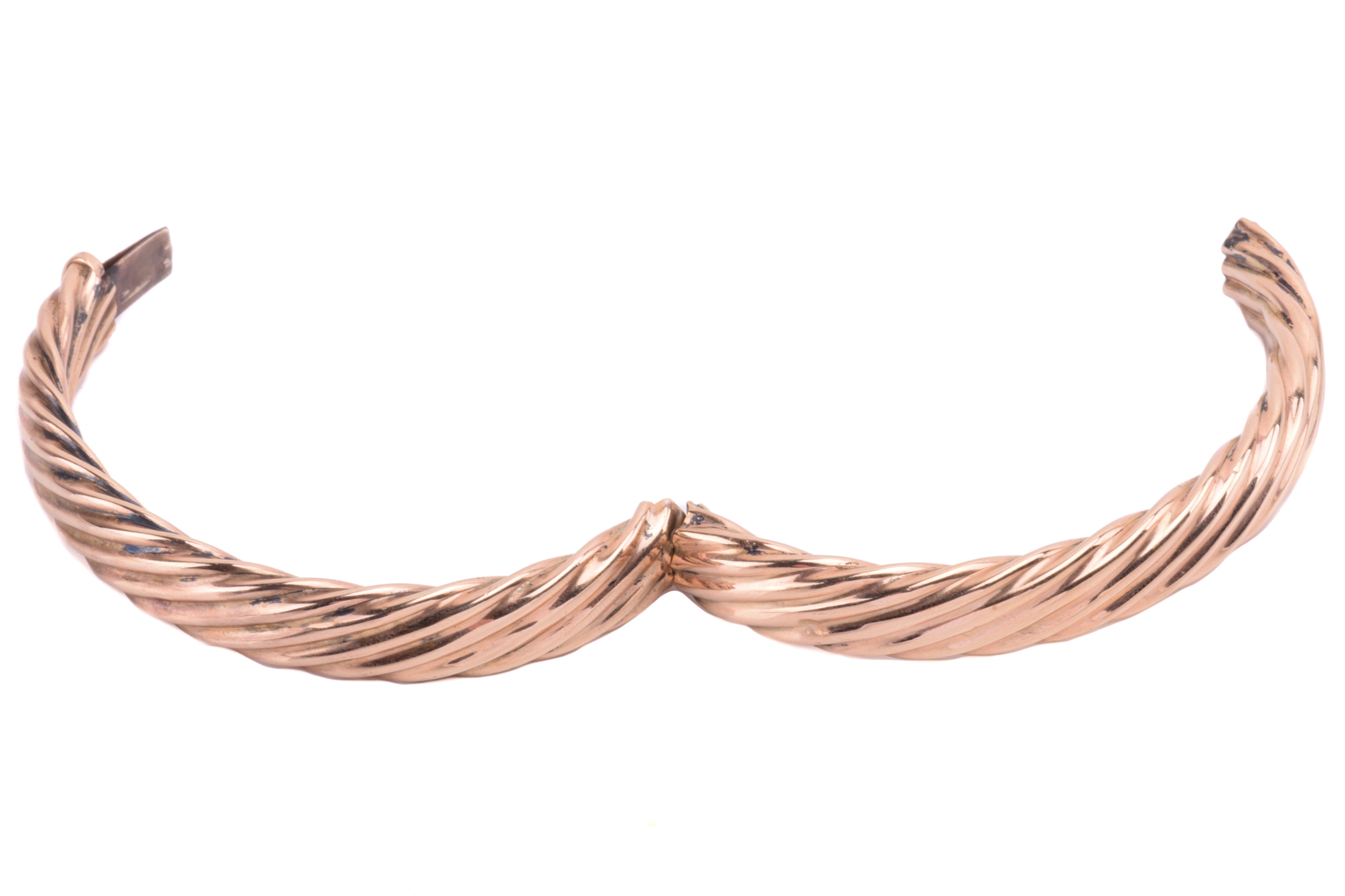 Lot 111 - A hinged bangle in twisted rope design, the