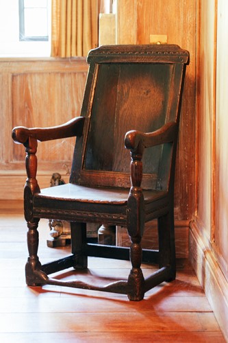 Lot 27 - A 17th century oak panel back open armchair,...