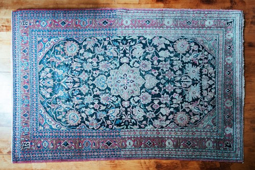 Lot 110 - An antique black/blue ground Kerman carpet,...