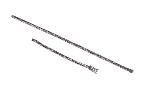 Lot 192 - A black diamond tennis bracelet, set with a...