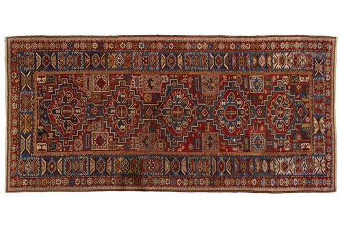 Lot 180A - An antique red ground Shirvan carpet with five...