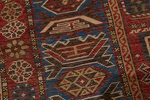 Lot 180 - An antique red ground Shirvan carpet with five...