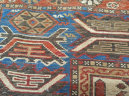 Lot 180 - An antique red ground Shirvan carpet with five...