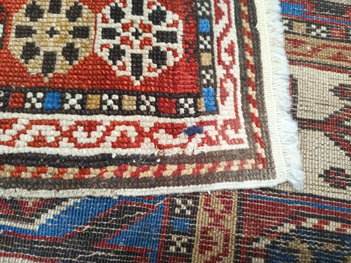 Lot 180 - An antique red ground Shirvan carpet with five...