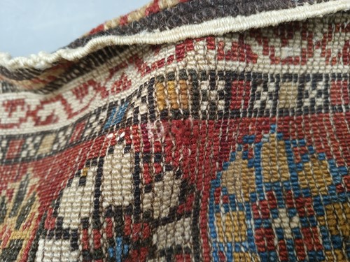 Lot 180 - An antique red ground Shirvan carpet with five...