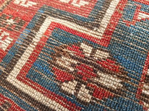 Lot 180 - An antique red ground Shirvan carpet with five...