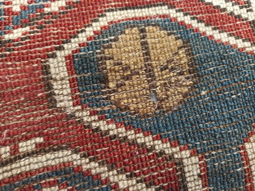 Lot 180 - An antique red ground Shirvan carpet with five...