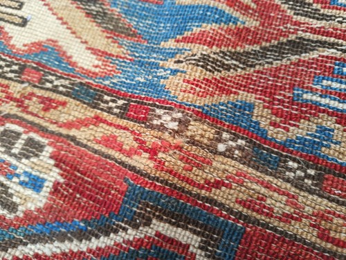 Lot 180 - An antique red ground Shirvan carpet with five...
