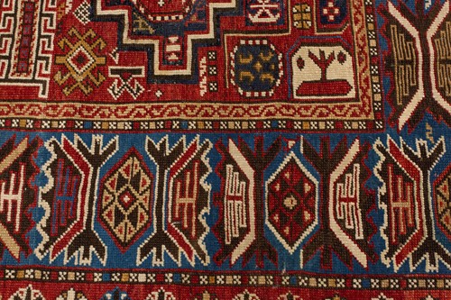 Lot 180 - An antique red ground Shirvan carpet with five...