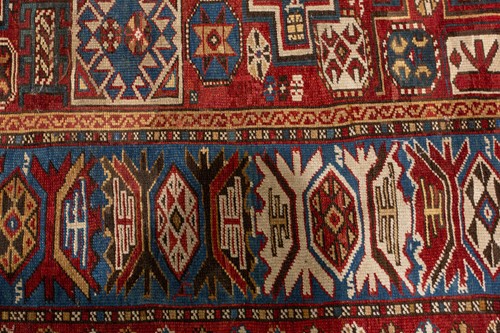 Lot 180 - An antique red ground Shirvan carpet with five...
