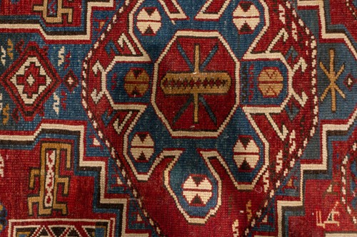 Lot 180 - An antique red ground Shirvan carpet with five...