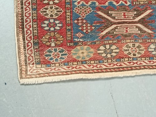 Lot 180 - An antique red ground Shirvan carpet with five...
