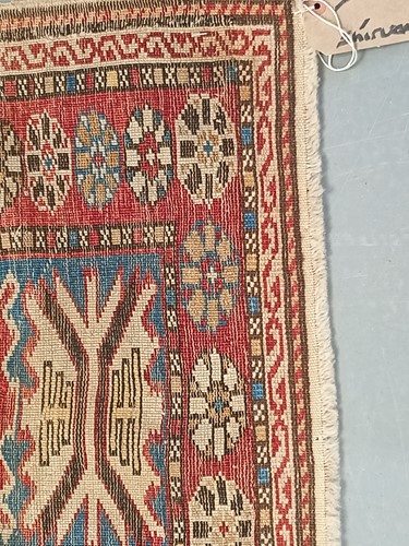 Lot 180 - An antique red ground Shirvan carpet with five...