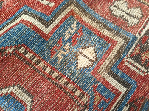 Lot 180 - An antique red ground Shirvan carpet with five...