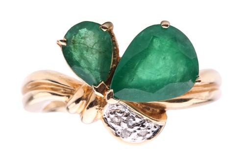 Lot 318 - An emerald dress ring featuring two...