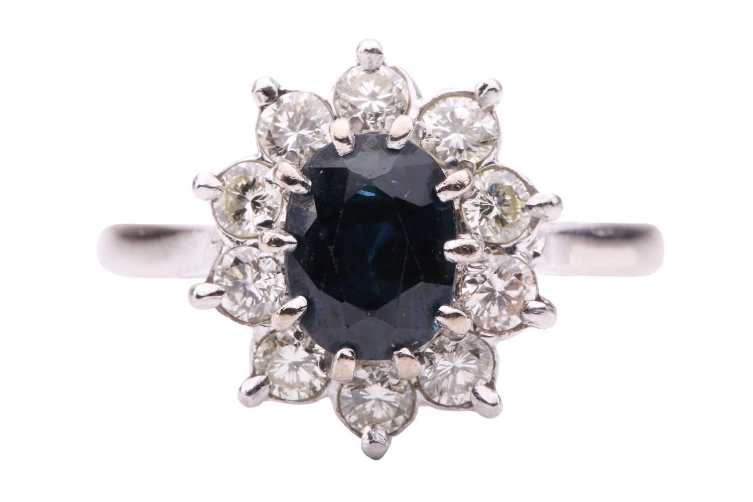Lot 89 - A sapphire and diamond cluster ring, centred...
