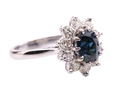 Lot 89 - A sapphire and diamond cluster ring, centred...