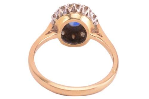 Lot 8 - A sapphire and diamond halo ring in 18ct gold,...