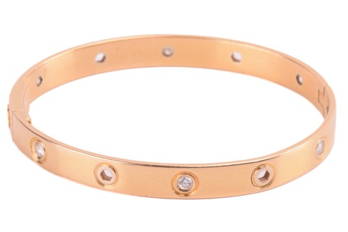 Lot 290 - Cartier - a diamond-set hinged bracelet in...