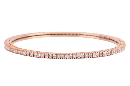 Lot 100 - A diamond bangle, set with a continuous row of...