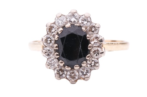 Lot 15 - A sapphire and diamond cluster ring, featuring...