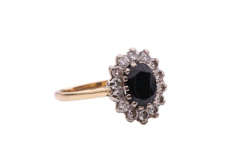 Lot 15 - A sapphire and diamond cluster ring, featuring...