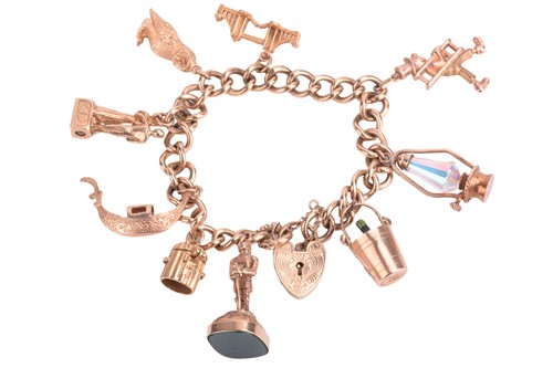 Lot 39 - A 9ct gold charm bracelet with multiple charms,...
