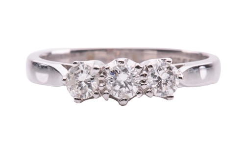 Lot 132 - A diamond three-stone ring in 18ct white gold,...