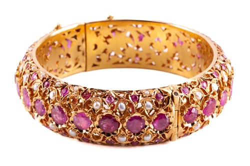 Lot 96 - A pink sapphire and pearl hinged bangle,...