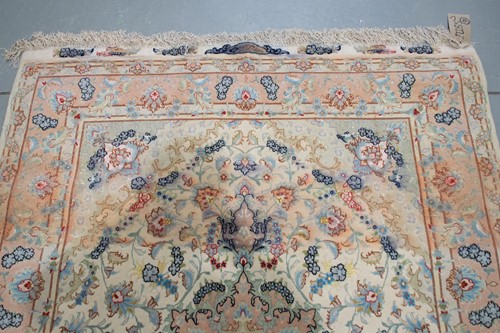 Lot 192 - A graduated ivory and peach ground Tabriz rug...