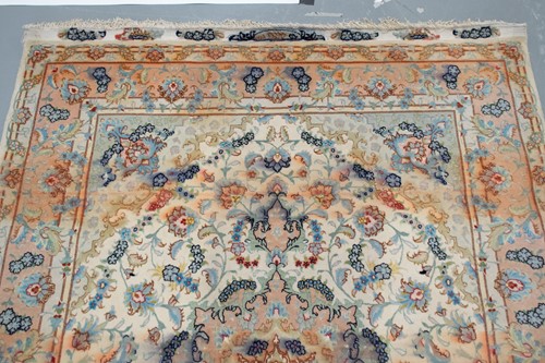 Lot 192 - A graduated ivory and peach ground Tabriz rug...