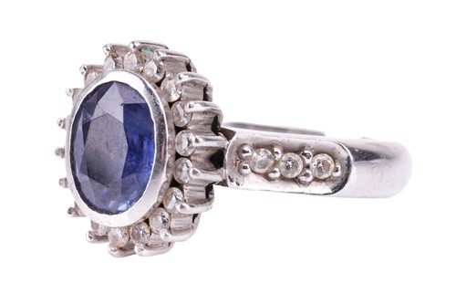 Lot 155 - A sapphire and diamond cluster ring; the oval...