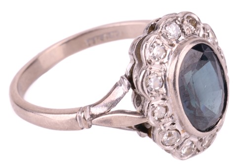 Lot 15 - A sapphire and diamond entourage ring, centred...