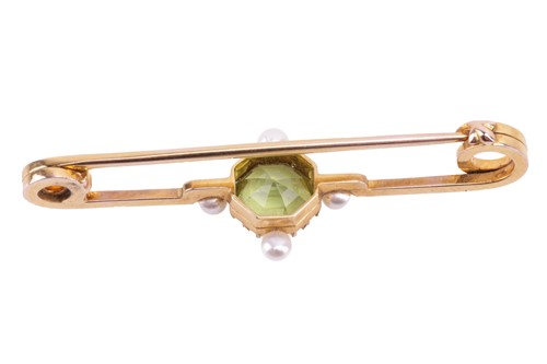 Lot 82 - A peridot and pearl bar brooch, set with an...