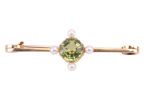 Lot 82 - A peridot and pearl bar brooch, set with an...