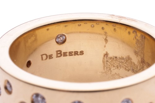 Lot 147 - De Beers - a diamond-set dress ring in 18ct...