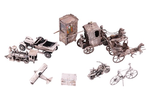 Lot 267 - A collection of silver travel-themed miniature...