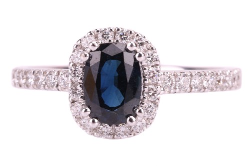 Lot 116 - A sapphire and diamond cluster ring, the dark...