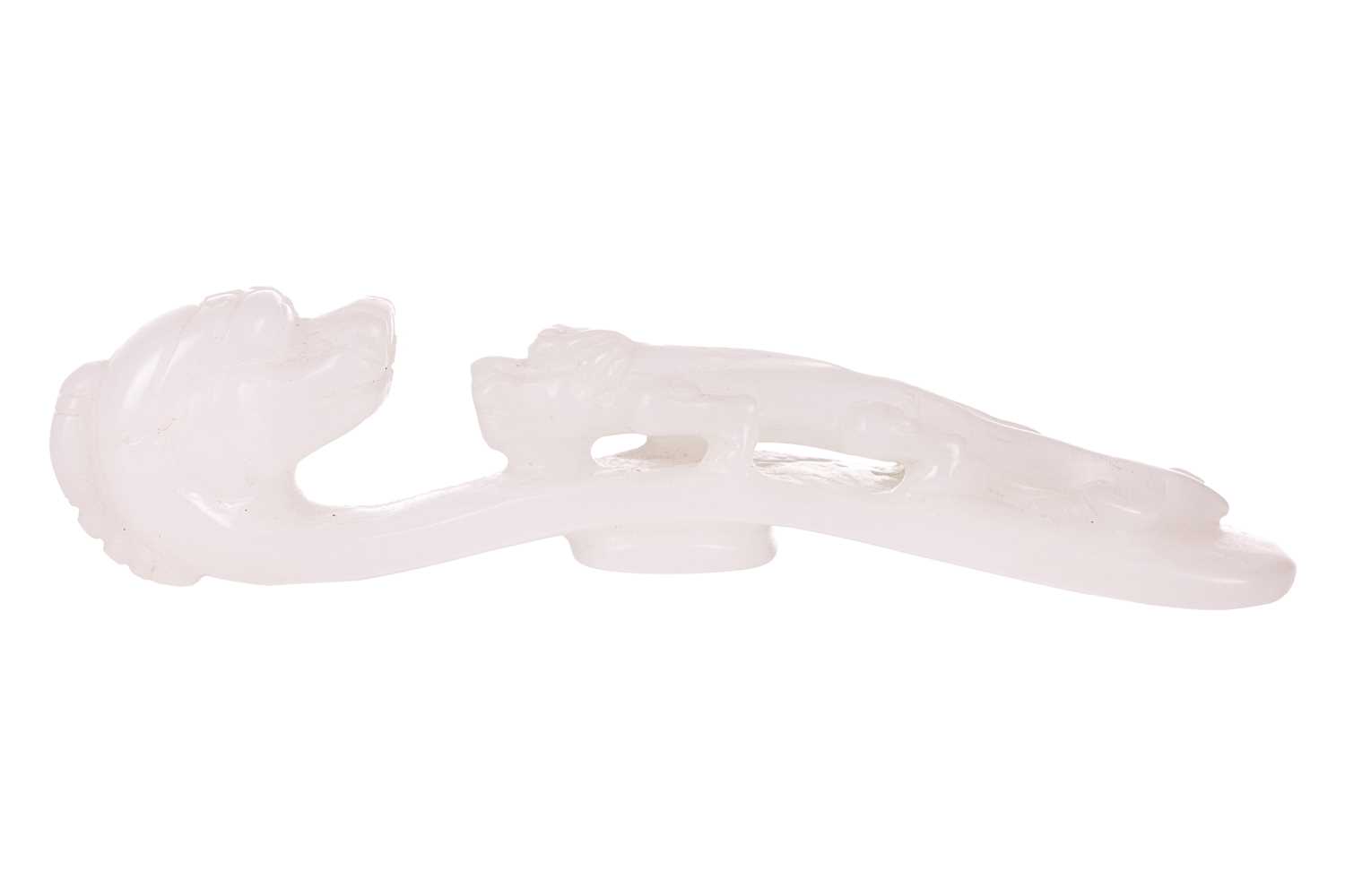 Lot 38 - A Chinese carved white jade fibular belt hook,...