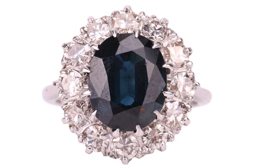 Lot 14 - A sapphire and diamond cluster ring, the oval...