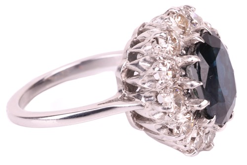 Lot 14 - A sapphire and diamond cluster ring, the oval...